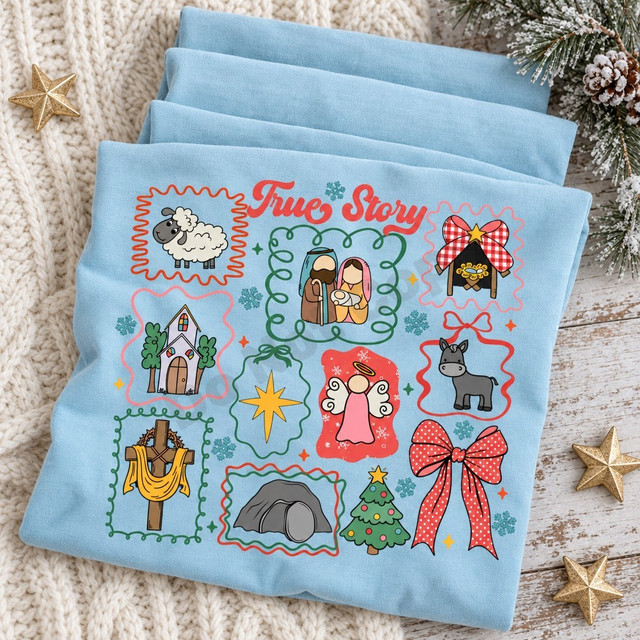 True Story nativity DTF transfer with hand-drawn sticker-sheet grid featuring the holy family, sheep, donkey, church, angel, manger, star of Bethlehem, cross, empty tomb, Christmas tree, and polka-dot bow framed by scribbly borders and snowflakes Shown on a Ice Blue t-shirt.