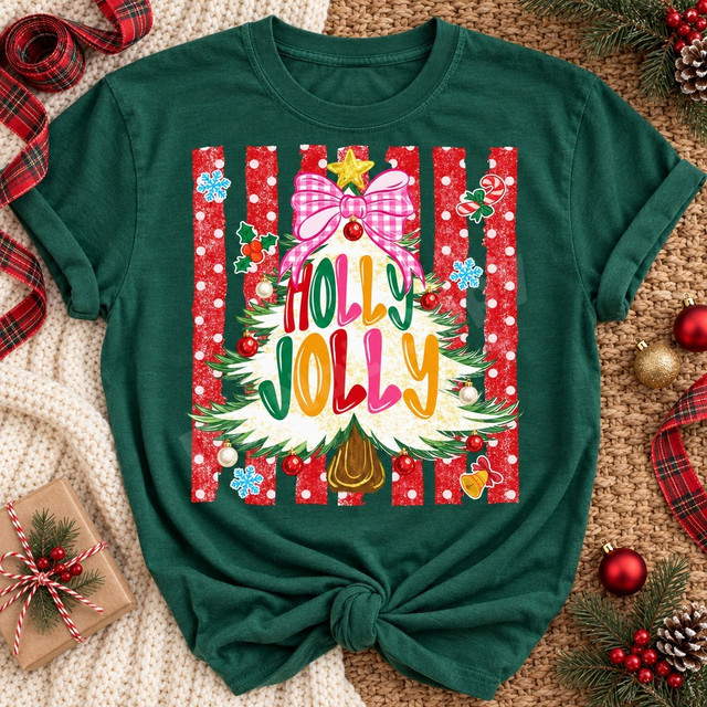 Holly Jolly Christmas DTF transfer with fluffy white tree, pink gingham bow, gold star, ornaments, and bubble lettering on a red striped polka dot background Shown on a Emerald t-shirt.