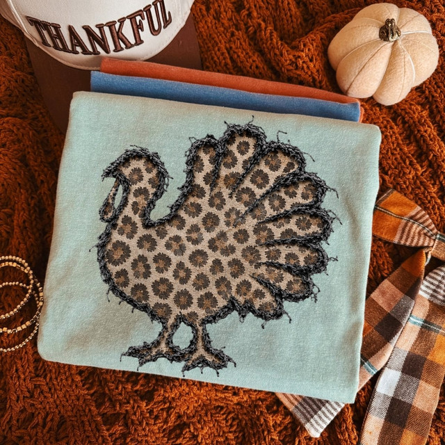 Leopard print turkey DTF transfer with faux stitched applique outline on a mint shirt, fall Thanksgiving design