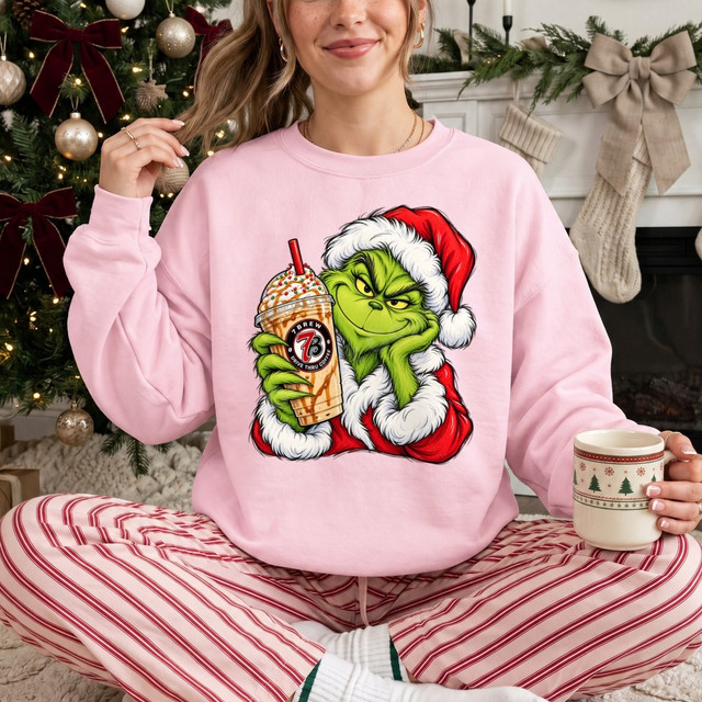 Green grumpy Christmas character in Santa suit holding an iced coffee drink DTF transfer design