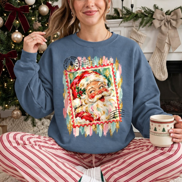 North Pole Santa postage stamp DTF transfer with painterly Santa Claus face, holly, and vintage postmark design on a sweatshirt