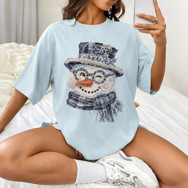 Winking snowman face DTF transfer with denim-style top hat, leopard print band, pearl trim, plaid scarf, and glasses in a chic rustic winter design