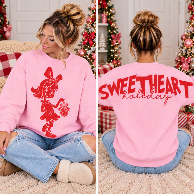 Pink Christmas sweatshirt with red holiday character front transfer holding an ornament and oversized Sweetheart Holiday back lettering