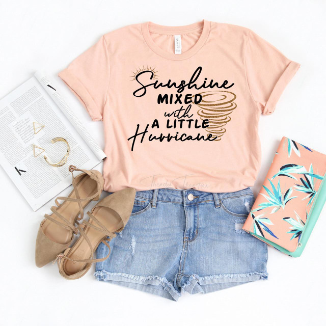 Sunshine mixed with a little hurricane glitter ADULT Screen Print Heat Transfer t-shirt, featuring a peach-colored fabric with black and golden print and a tornado graphic.