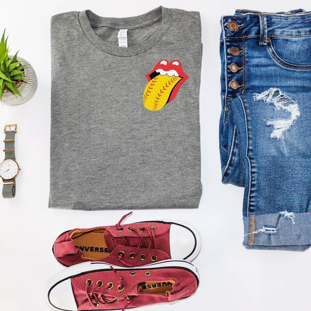 Softball Tongue Lips POCKET -FINAL STOCK Screen Print Heat Transfer, gray T-shirt with a tongue and lips softball graphic, paired with distressed denim jeans, red Converse sneakers, and a wristwatch.