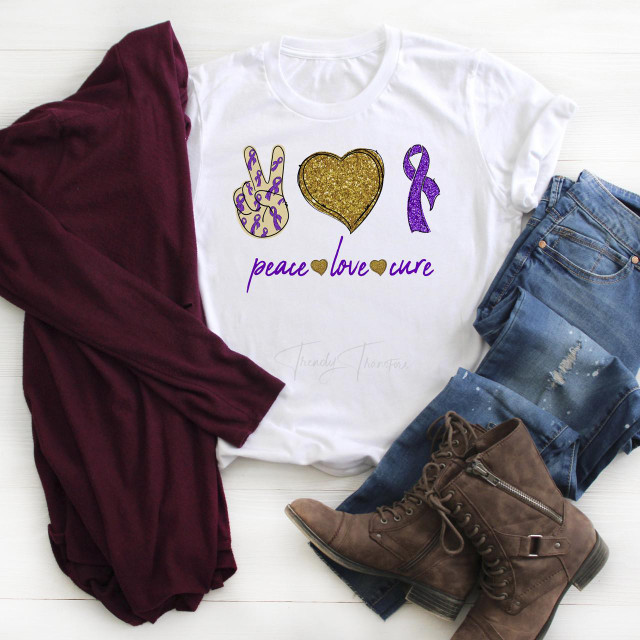 Purple Ribbon Awareness Glitter Heart Peace Love Cure Sublimation Transfer, white T-shirt with purple and gold ribbon and heart design, paired with blue distressed jeans, brown boots, and a maroon scarf.