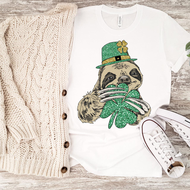 Lucky Sloth Clover glitter St. Patrick's Day Sublimation Transfer, a graphic of a cute sloth wearing a green glitter St. Patrick's Day hat and holding a green glitter shamrock, perfect for holiday-themed apparel or accessories.