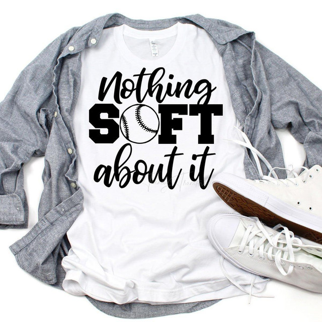 Nothing Soft About It Softball Sublimation Transfer, graphic T-shirt with softball graphic and sporty text, laid flat with casual sneakers and a gray shirt to showcase the sports-themed apparel.