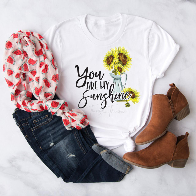 You are my sunshine Sunflower vase Sublimation Transfer, floral sunflower design on a white T-shirt surrounded by casual clothing and brown ankle boots.