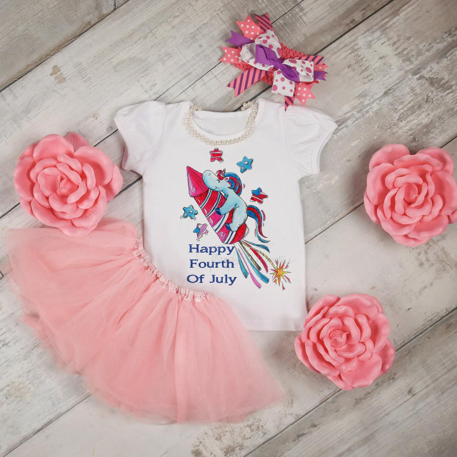Unicorn fireworks Patriotic 4th of July Sublimation Transfer, baby girl's birthday outfit with a unicorn and fireworks design on a white shirt, pink tutu skirt, decorative pink flowers, and a colorful ribbon bow.