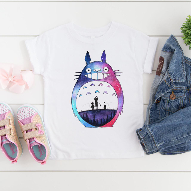 Totoro watercolor Sublimation Transfer, colorful graphic of Totoro with galaxy-inspired design and a silhouette of children playing, printed on a white T-shirt.