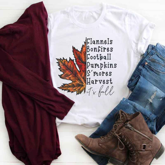 It's Fall Sublimation Transfer, a white t-shirt featuring fall-themed text and an autumn leaf graphic, paired with a maroon cardigan, distressed jeans, and brown lace-up boots for fall fashion.