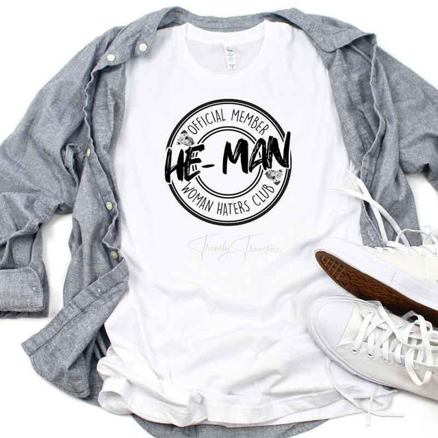 He Man Woman Haters Club Sublimation Transfer, white t-shirt with black circular logo design and text, casual clothing style with gray shirt and white sneakers.