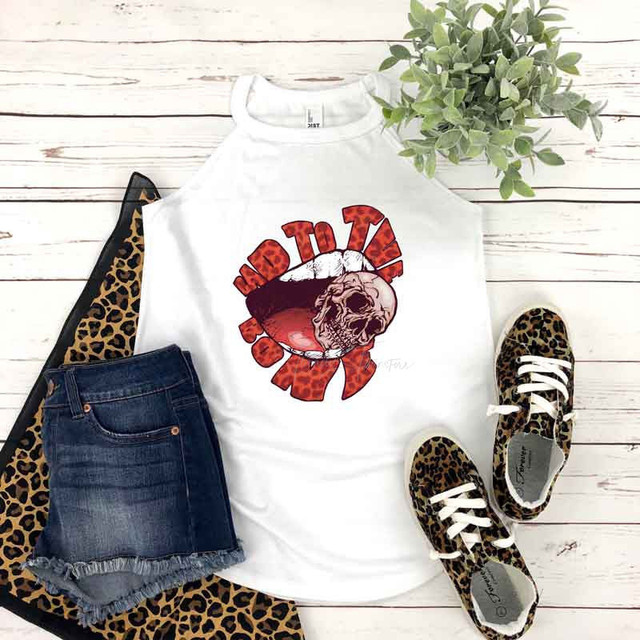 Leopard Bad To The Bone Sublimation Transfer, showcasing a white sleeveless top with a leopard print skull and bone design, paired with leopard print sneakers, denim shorts, and a leopard print scarf on a white wooden background with a green plant.
