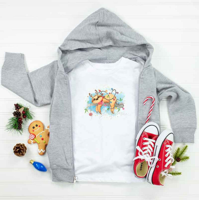 Christmas Watercolor Sloth Sublimation Transfer, white t-shirt with a watercolor-style sloth Christmas illustration.