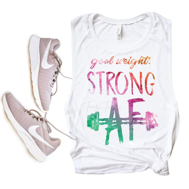 Goal Weight Strong AF Sublimation Transfer, fitness themed white tank top with colorful text and a green barbell graphic, displayed alongside pink Nike running shoes.