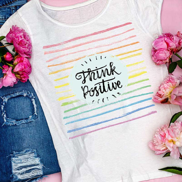 Think Positive Sublimation Transfer, colorful rainbow stripe t-shirt with the inspirational message, surrounded by pink flowers.