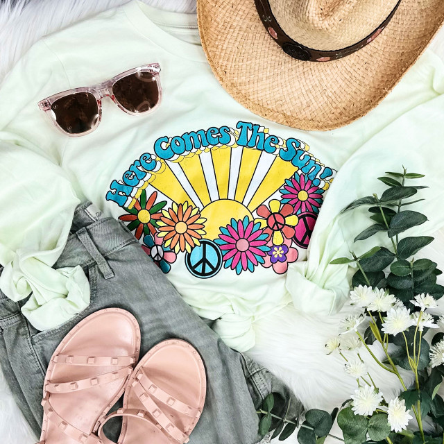 Here Comes The Sun Screen Print Heat Transfer, colorful sun, flowers, peace symbols, and text design on a white shirt.