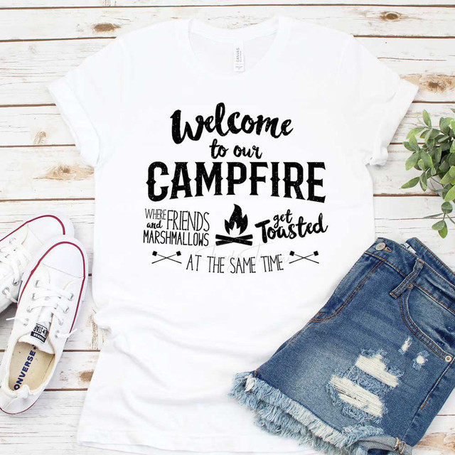 Welcome To Our Campfire Sublimation Transfer, white T-shirt with a campfire and marshmallow roasting graphic and text design.