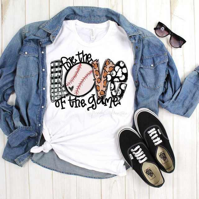 For The Love of The Game Baseball Sublimation Transfer, casual outfit featuring a white T-shirt with a baseball graphic and playful text, denim jacket, black Vans sneakers, and sunglasses on a light wooden surface.
