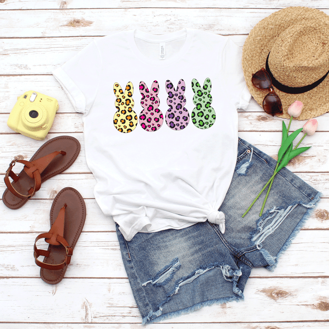 Leopard Peeps Sublimation Transfer, colorful leopard-print bunny designs on a white T-shirt with casual summer accessories.