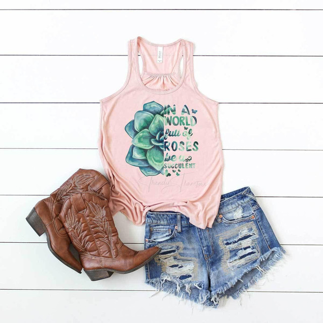 Be A Succulent FINAL STOCK Screen Print Heat Transfer T-shirt with a succulent plant graphic and the text 'In a world full of roses be a succulent,' paired with distressed denim shorts and brown cowboy boots.