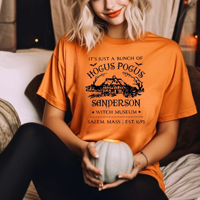It's Just A Bunch Of Hocus Pocus Screen Print Transfer, an orange t-shirt featuring a Halloween-themed design with spooky house, bats, and text celebrating Salem, Massachusetts witch history.