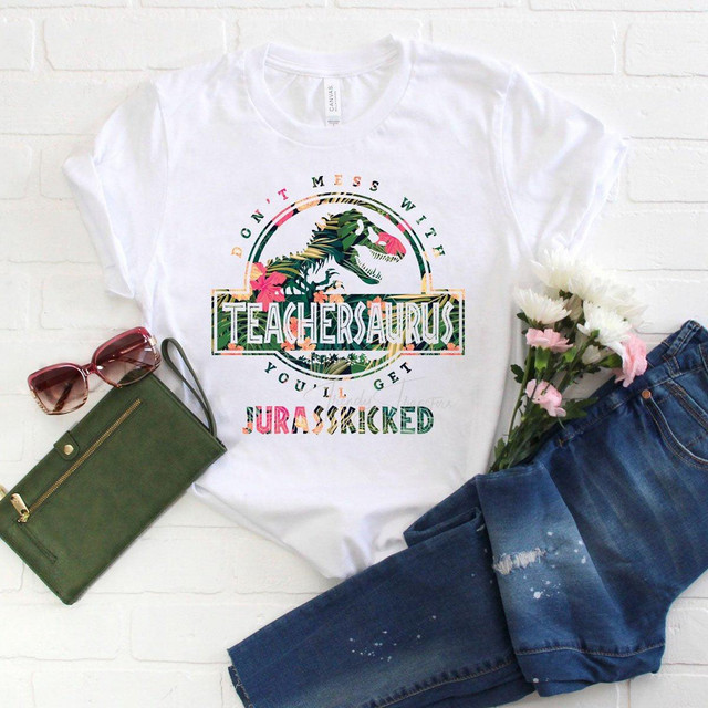 Don't Mess With Teachersaurus You'll Get Jurasskicked Tropical Sublimation Transfer, a colorful dinosaur-themed graphic t-shirt for teachers and dinosaur lovers.