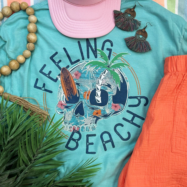 Feeling Beachy Skull Screen Print Heat Transfer, beach-themed apparel featuring a skull with a palm tree, surfing, and floral design.