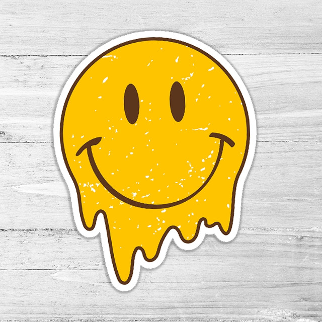 Melting Smiley Retro Die Cut Sticker, yellow melting smiley face with black eyes and a happy smile on a light wooden background.