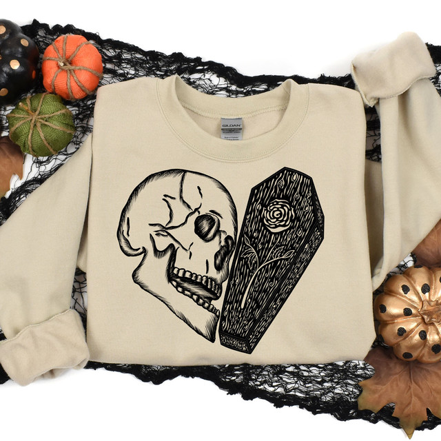 Coffin Skull Heart DTF Transfer, black graphic illustration of a skull and a coffin on a cream sweatshirt.