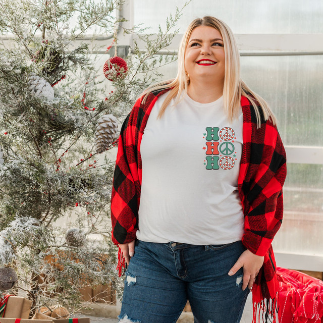 Ho Ho Ho Peace Sign POCKET Screen Print Heat Transfer, festive holiday design on a white T-shirt worn by a smiling woman in front of a decorated Christmas tree.