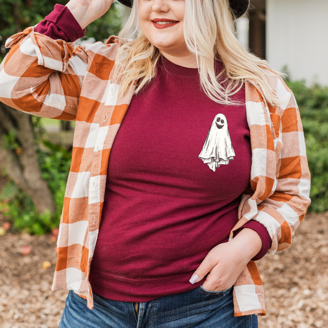 Ghost HAT/POCKET Screen Print Heat Transfer, Halloween ghost illustration on a maroon t-shirt worn by a woman outdoors.