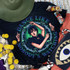 Dance Like Nobody's Watching Screen Print Heat Transfer, vibrant graphic design featuring a woman with dark hair in a dynamic dance pose surrounded by skulls and barbed wire, on a black fabric.