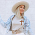 Distressed Cross DTF Heat Transfer, a brown cross design on a woman's beige t-shirt.