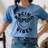 Racing Vibes Happy Face DTF Heat Transfer, a cheerful smiley face wearing checkered sunglasses, on a blue t-shirt.