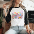 Happy Face Lattes DTF Heat Transfer, colorful illustration of various smiling coffee cups and drink accessories on a woman's white and black long sleeve shirt.