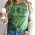 Fresh Herbs DTF Heat Transfer, a green T-shirt with black outline illustrations of herbs and the words 'fresh herbs' printed on it.