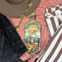 Last Night Liquor Screen Print Heat Transfer, colorful graphic of a liquor bottle with desert scene, mountains, cactus, guitar, and car, on pink fabric.
