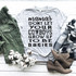 Mamas Don't Let Your Cowboys Grow Up To Be Babies Sublimation Transfer, a printed T-shirt with text about mothers and cowboys, surrounded by fashion items like an olive green jacket, plaid scarf, tan shoes, and cotton branches on a white wooden background.