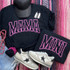 Mama PUFF Screen Print Heat Transfer, black T-shirts with pink outlined text 'MAMA' and 'MINI', fashion sneakers with star logo, accessories including earrings, cap, and jewelry displayed on a striped fabric background.