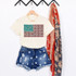 Stone USA Flag Screen Print Heat Transfer, fabric heat transfer design of the United States flag with animal print patterns and red, white, and blue colors displayed on a cream t-shirt, with denim shorts and a red and blue patterned scarf in the background.