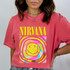 Nirvana T-shirt, digital print of a colorful smiley face with tongue out, featuring the Nirvana band name in bold yellow letters, showcasing DTF heat transfer design on a pink cotton T-shirt.