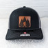 Bigfoot Leather Hat Patch, a rectangular patch featuring a silhouette of Bigfoot walking among trees against a sunset background, designed for outdoor and casual hats.