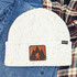 Bigfoot Leather Hat Patch, white knit beanie hat with a leather patch depicting Bigfoot in a forest scene.