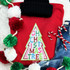 Sequin Christmas Tree Patch, colorful embroidered holiday tree design on red sweatshirt with holiday accessories around.