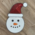 Sequin Snowman Patch, festive snowman face with a red Santa hat decorated with sequins on a wooden surface.
