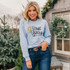 True Story Star DTF Heat Transfer, woman wearing a light blue sweatshirt with 'True Story' and Bible verse Luke 2:10-20 printed on it.