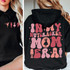 In My Nutcracker Mom Era DTF Heat Transfer, a design featuring silhouettes of ballet dancers, nutcracker figures, and a girl with a nutcracker on her head, in pink and peach colors on black hoodies.
