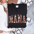 Mama Cowhide Pink DTF Heat Transfer, pink and brown cowhide pattern spelling MAMA on a black T-shirt.